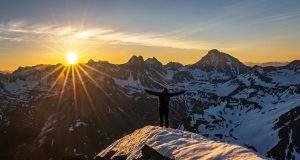 Making it Big in Life: How To Succeed man standing on the mountain looking at the sun, indicating making it big in life