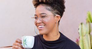 How To Live A Soft Life A relaxed woman smiling softly while holding a coffee cup, capturing the calm and peaceful feeling of how to live a soft life.
