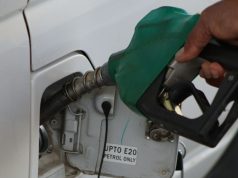 The Impact of Increased Fuel Prices in Nigeria A black man’s hand holding a fuel pump at a car fueling station, representing the impact of increased fuel prices in Nigeria.