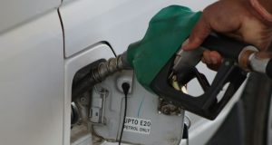 The Impact of Increased Fuel Prices in Nigeria A black man’s hand holding a fuel pump at a car fueling station, representing the impact of increased fuel prices in Nigeria.