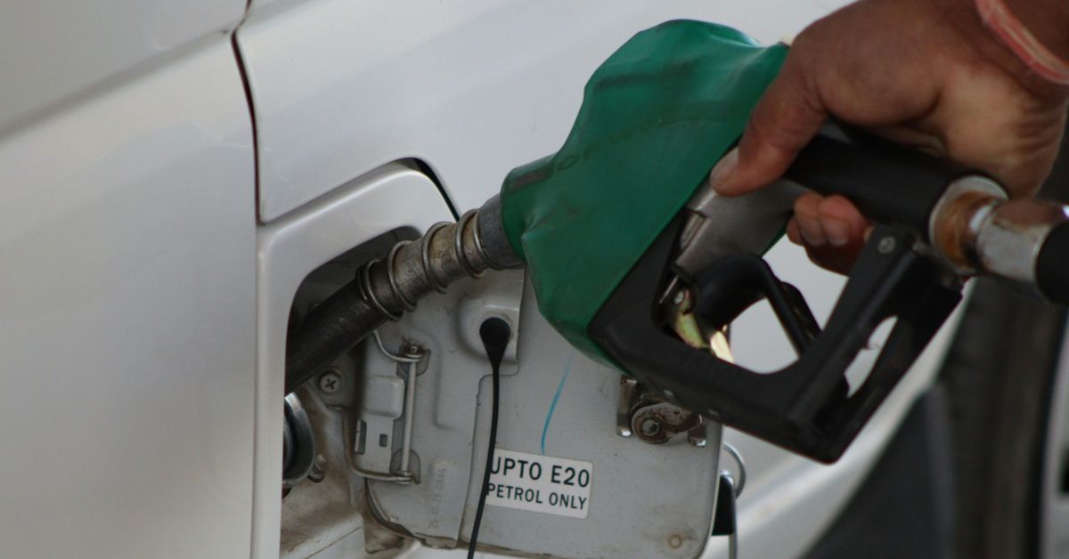 A black man’s hand holding a fuel pump at a car fueling station, representing the impact of increased fuel prices in Nigeria.