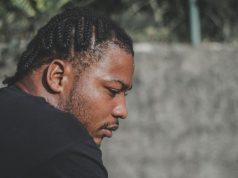 How To Be Mentally Strong A black man with cornrows looking calm and reflective outdoors, representing how to be mentally strong and maintain resilience during life’s challenges.
