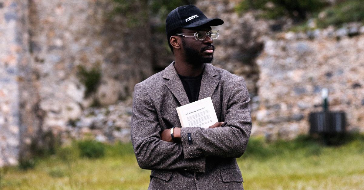A confident black man wearing a blazer and face cap, standing outdoors with folded arms and looking to the right, symbolizing self-assurance and independence — a perfect visual for how to have a mind of your own.