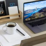 Minimal workspace setup with laptop, coffee, and notepad representing business planning and entrepreneurship in 2023 and 2024.