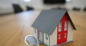 How To Invest In Real Estate With No Money A miniature house with keys on a wooden table, representing how to invest in real estate with no money, property ownership, and financial growth.