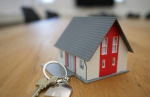 How To Invest In Real Estate With No Money A miniature house with keys on a wooden table, representing how to invest in real estate with no money, property ownership, and financial growth.