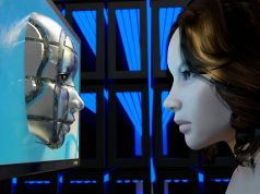 How AI Is Reshaping Software Development in 2025 A futuristic female AI interacting with a robotic face emerging from a computer screen, symbolizing how AI is reshaping software development in 2025.