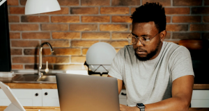 25 High-Paying Remote Jobs You Can Land in 2025 (No Coding Required) a man working from home on his laptop, demonstrating 25 high-paying remote jobs 2025