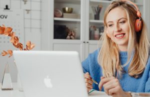 How to Use Google Gemini AI for Remote Work Productivity: Tools, Tips & Best Practices A woman using Google Gemini AI for remote work productivity, smiling while working on her laptop with a pencil in hand.