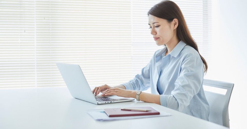 A professional writing a follow-up email after a business meeting to ensure clear communication and next steps.