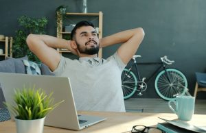 10 Proven Stress Management Techniques for Professionals Working Remotely A remote professional applying stress management techniques for remote professionals, relaxing at home after work with a laptop on the desk.