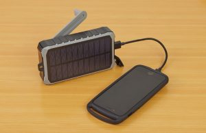 How to Make Your Oraimo Power Bank Last Longer (Real Tips That Work) Power bank charging phone on wooden surface – how to make your Oraimo power bank last longer.