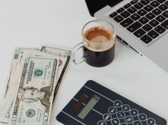 How to Open a Dollar Domiciliary Account in Nigeria Laptop, coffee, and dollar notes on white table – how to open a dollar domiciliary account in Nigeria.