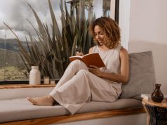 10 Simple Self-Care Routines Every Busy Woman Can Start Today A woman enjoying a peaceful morning self-care moment, sitting by the window with a journal and pen, practicing simple self-care routines for busy women.