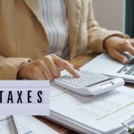 Close-up of hands reviewing tax documents with a calculator and pen, representing 2026 tax compliance in Nigeria
