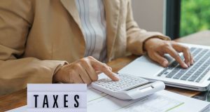 Nigerian Government to Enforce Strict Tax Compliance in 2026: What You Must Do Now to Avoid Penalties Close-up of hands reviewing tax documents with a calculator and pen, representing 2026 tax compliance in Nigeria