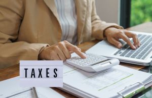 Nigerian Government to Enforce Strict Tax Compliance in 2026: What You Must Do Now to Avoid Penalties Close-up of hands reviewing tax documents with a calculator and pen, representing 2026 tax compliance in Nigeria