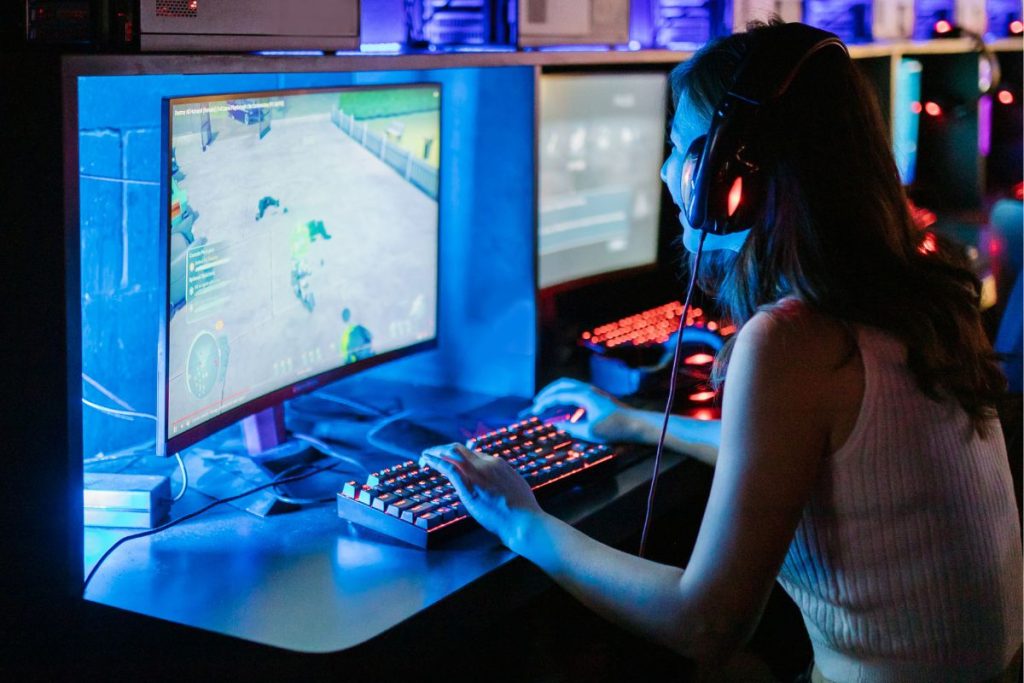 Woman wearing headphones using a computer system, illustrating how to protect your devices from malware and online scams
