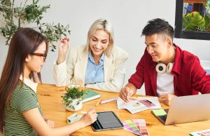 How To Turn Your Passion Into a Profitable Side Hustle Three entrepreneurs brainstorming business ideas while learning how to turn your passion into a profitable side hustle.