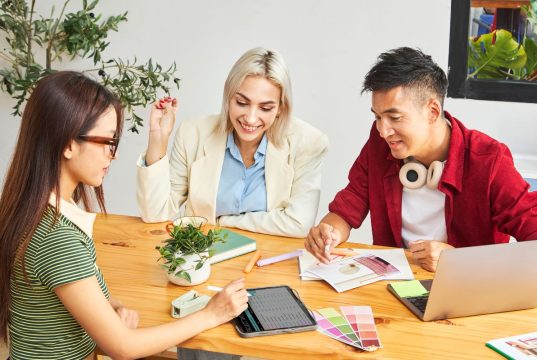 How To Turn Your Passion Into a Profitable Side Hustle Three entrepreneurs brainstorming business ideas while learning how to turn your passion into a profitable side hustle.